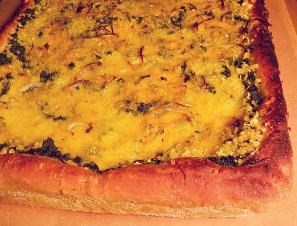 veganer Käse auf Spinatpizza - close up